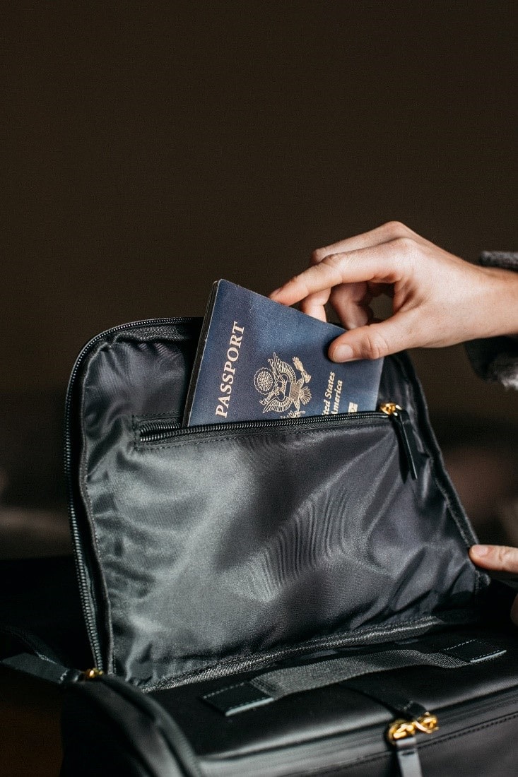 A person putting their passport in a bag-min