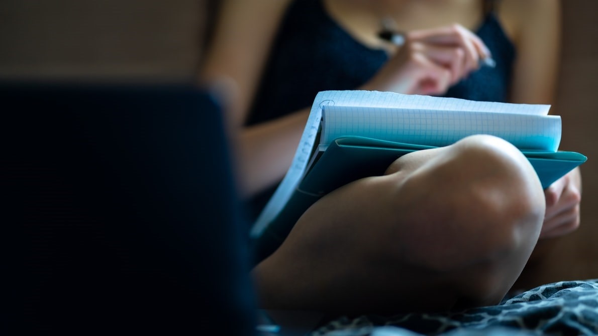 Woman sitting and writing down on pape