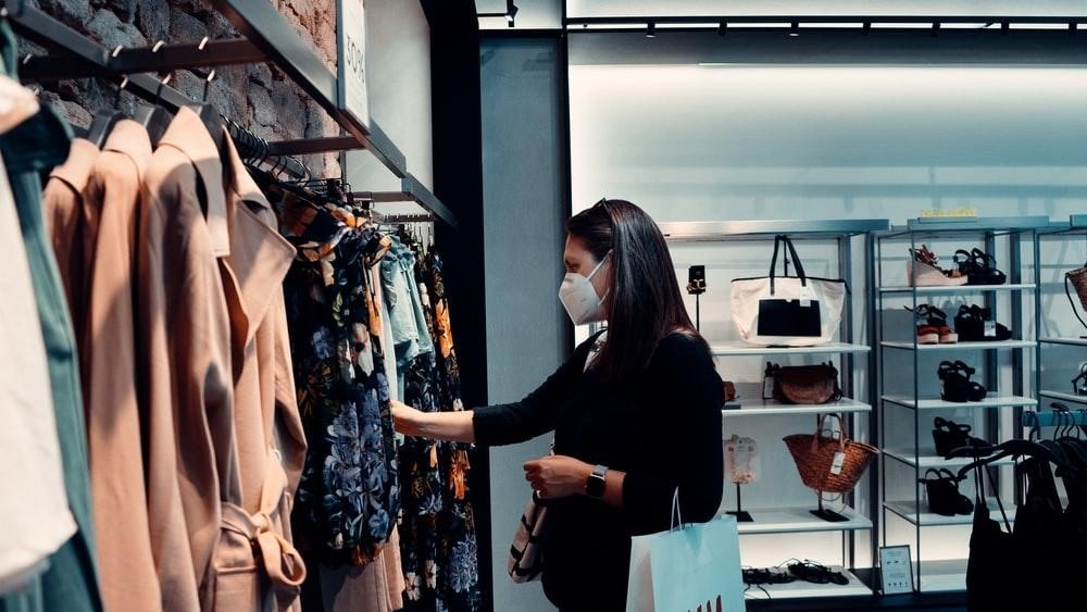 a woman browsing clothes in a shop