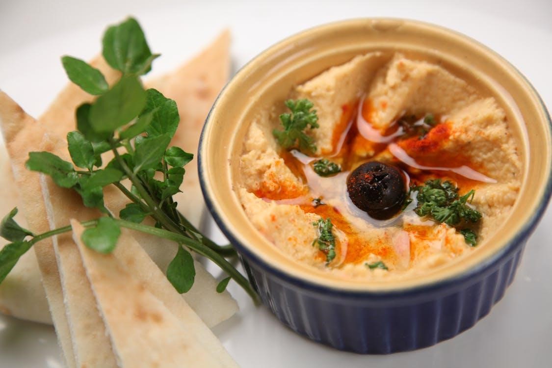 a bowl of hummus with pita